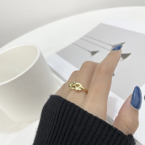 Détail d'une bague nœud dorée minimaliste montrant le design élégant et enroulé