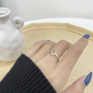 Detailed view of an S925 sterling silver geometric square ring worn on a woman's finger