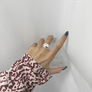 Macro shot of wide S925 sterling silver ring with polished mirror finish on hand