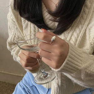 Elegant S925 sterling silver oval ring shown on model holding a clear glass