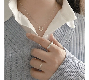 Close-up of S925 sterling silver irregular circle necklace and rings on woman