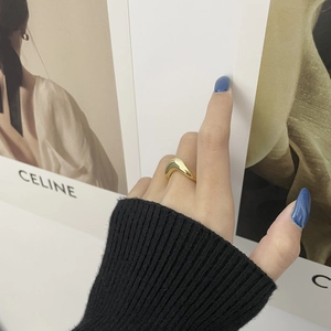 Nahaufnahme eines minimalistischen goldenen Wellenrings in einem modernen Stil-Set