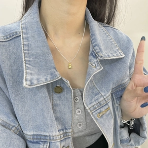 Dettaglio di una collana in argento s925 con ciondolo a orso bicolore sul collo