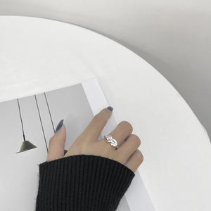 Gros plan d'une bague tressée minimaliste en argent S925 portée au doigt