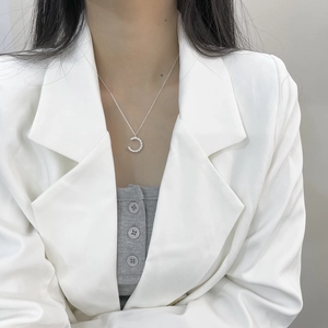 Collier minimaliste en argent sterling 925 avec pendentif lettre C sur un blazer blanc