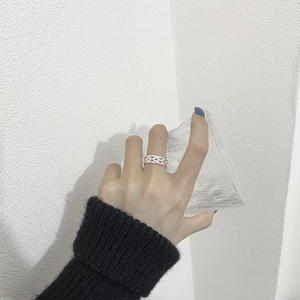 Detail of S925 sterling silver hollow chain ring worn by a model holding a glass
