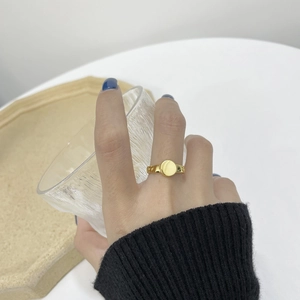 Minimalist gold S925 sterling silver ring with polished round face on a female model