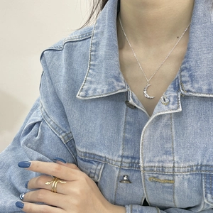 S925 silver crescent moon necklace and gold snake ring worn with a denim jacket