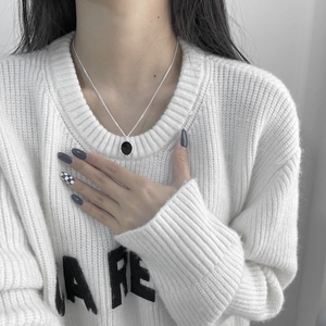 Collana vintage in argento S925 con pendente ovale in smalto nero su maglione bianco