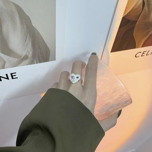 Détail de la bague coeur en argent avec zircons roses et verts sur la main du mannequin