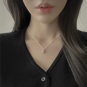 Detailed view of irregular silver pendant with freshwater pearl on a delicate chain