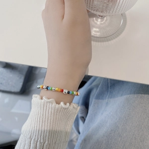 Close-up of a handmade colorful beaded bracelet with silver accents on a female wrist
