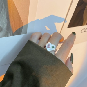 Bague cœur en argent 925 avec zircons rose et vert portée au doigt du modèle
