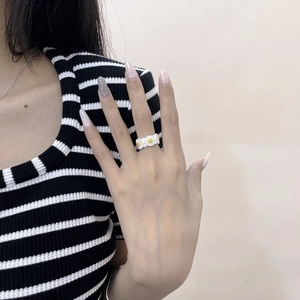 Close-up of S925 sterling silver daisy ring featuring three white and yellow flower petals