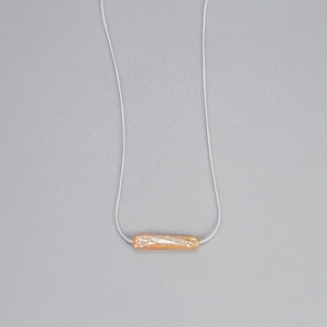 Detailed macro view of S925 silver snake chain with pink baroque pearl pendant