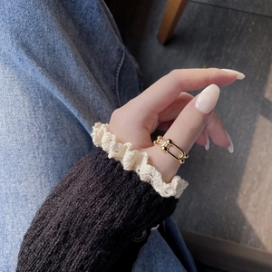 Detail shot of a minimalist gold U-shape chain ring worn on the index finger