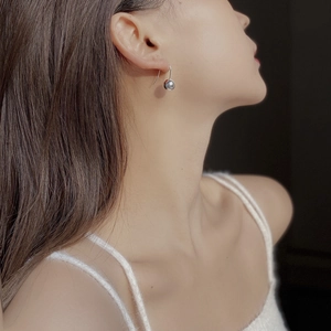Minimalist 925 sterling silver ball drop earrings worn by a model in a side view profile