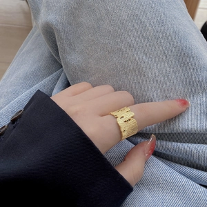 Irregular textured gold ring with tree bark patterns on index finger for women