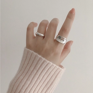 Detail of minimalist S925 sterling silver rings with thick and narrow bands on hand