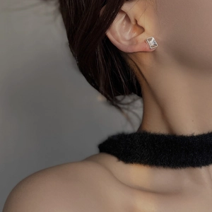 Close-up of minimalist square silver earring worn on model for a premium luxury look