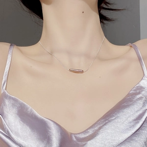 Macro shot of minimalist S925 sterling silver bar pendant on a sleek snake chain necklace