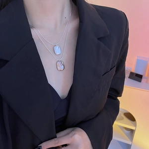 Detail of layered S925 silver necklace with white and champagne baroque pearl pendants