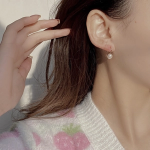 Elegant S925 silver gold hooks with natural freshwater pearls on a model's ear