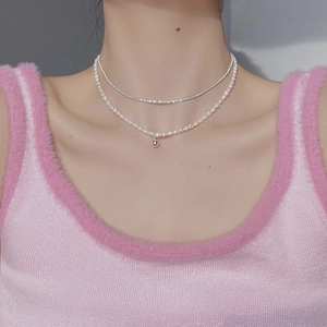 Close-up of double-layer S925 silver necklace with baroque pearls on pink vest