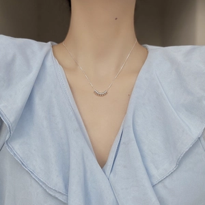 Minimalist 925 sterling silver necklace with seven beads worn on a collarbone model