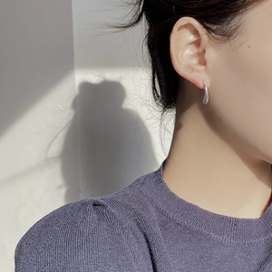 Close-up of minimalist S925 sterling silver water drop earrings with polished mirror finish