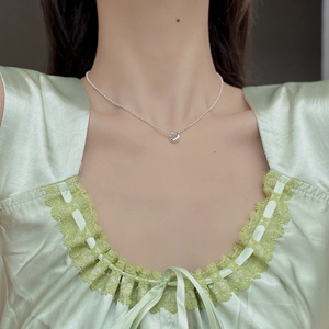 Close-up of minimalist 925 sterling silver beaded necklace with circular ring pendant