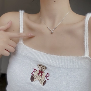 Gros plan d'un collier de perles en argent avec pendentif cœur sur un mannequin