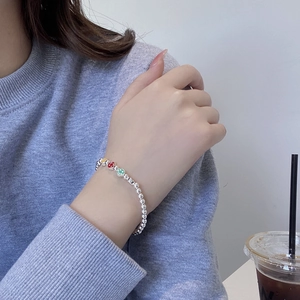 Gros plan d'un bracelet en perles d'argent S925 avec des breloques smiley en émail coloré