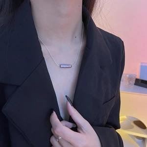 Close-up of minimalist S925 silver necklace with a long dark baroque pearl pendant