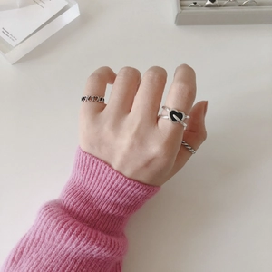 Close-up of S925 silver cross ring featuring a black heart and vintage stacking details