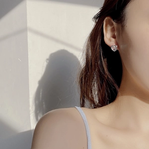 Macro shot of polished S925 sterling silver heart stud earring worn by model