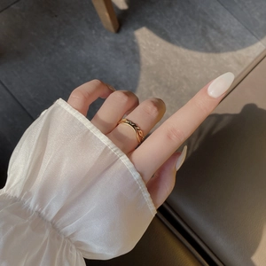Detail of minimalist 18K gold double twisted rope ring with elegant braided texture