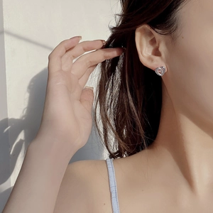 Elegant S925 sterling silver hollow heart stud earring worn on a female model