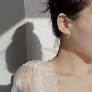 Orecchini minimalisti in argento 925 a doppia C indossati da una modella donna
