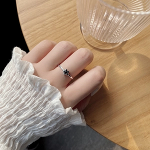 Detail of S925 sterling silver ring with black clover floral design on a hand