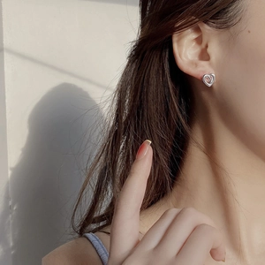Minimalist S925 sterling silver hollow heart earrings worn by a model in soft light