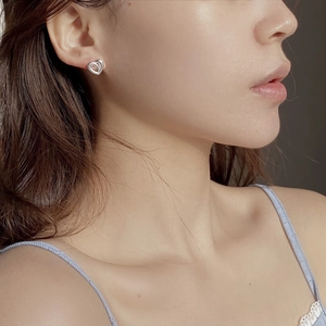 Close-up of heart-shaped S925 sterling silver stud earring on a woman's ear