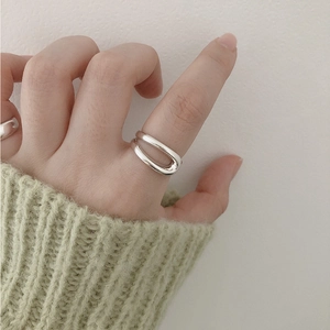 Close-up of S925 sterling silver hollow oval open ring worn with a green knitted cuff