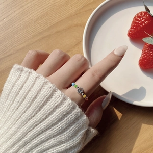 Detailed view of 925 silver smiley face charm on colorful elastic beaded ring