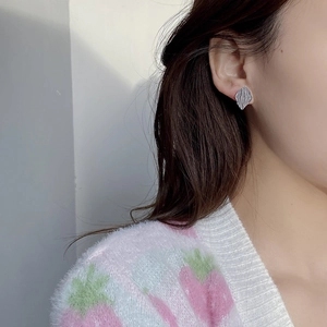 Detail of S925 sterling silver geometric leaf earring with pleated texture on model