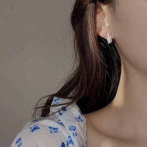 Close-up of irregular textured S925 sterling silver stud earring on female model