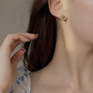 Minimalist gold S925 sterling silver heart stud earrings worn on a model ear
