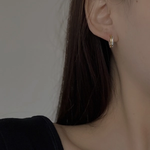 Close-up of minimalist S925 sterling silver hoop earrings with mixed gold and silver finish