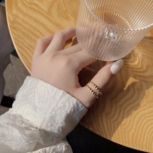 Close-up of double layer beaded gold silver ring shown on thumb in a lifestyle setting