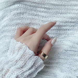 Nahaufnahme eines goldenen S925 Sterling Silber Mehrschichtrings auf weichem Strick